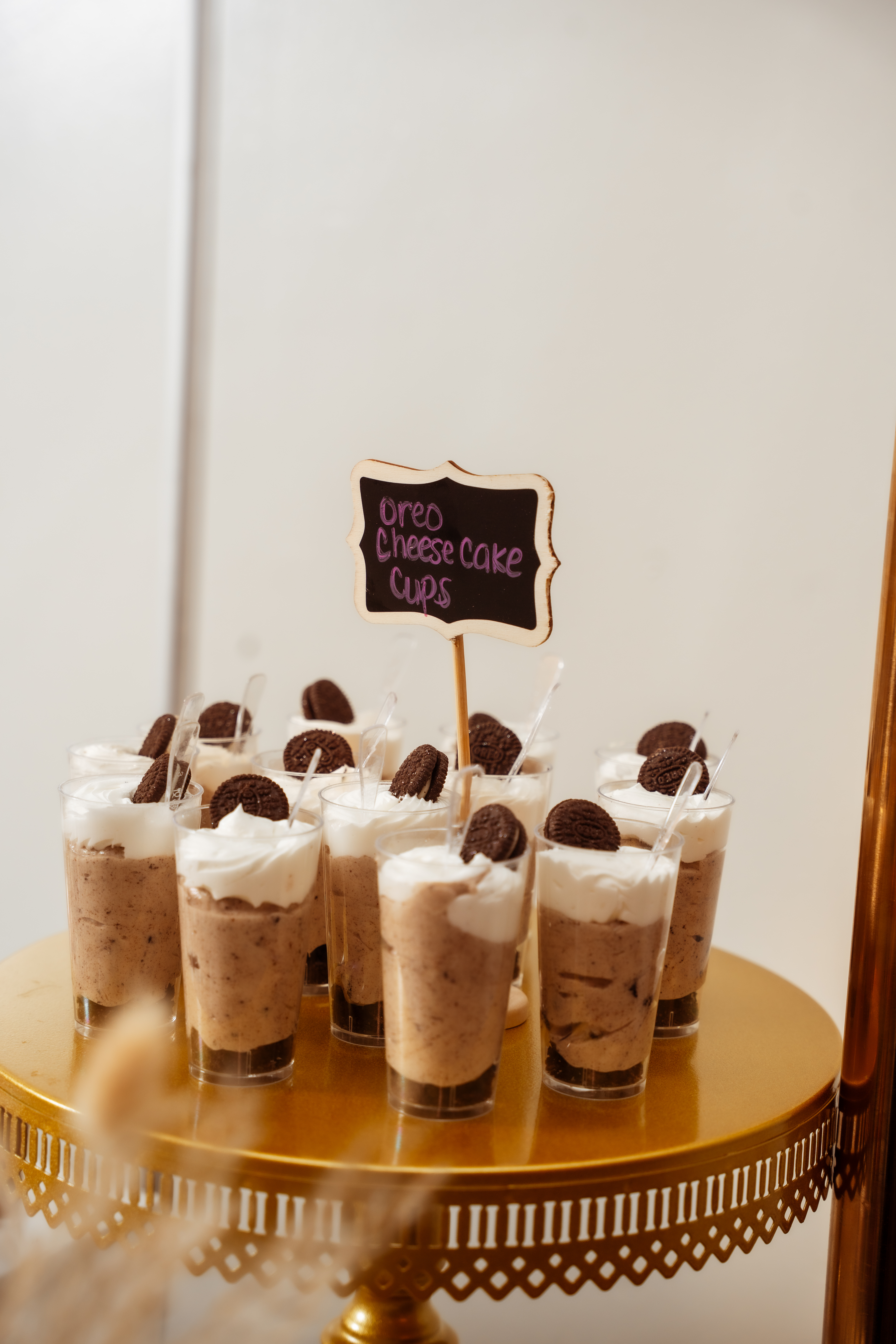 Oreo cheesecake dessert cups on a gold display stand